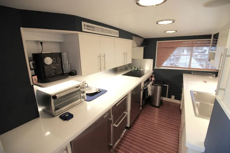 Freedom Yacht Photos Pics Modern kitchen interior on 1979 Burger Raised Pilothouse yacht, featuring sleek appliances and ample counter space.