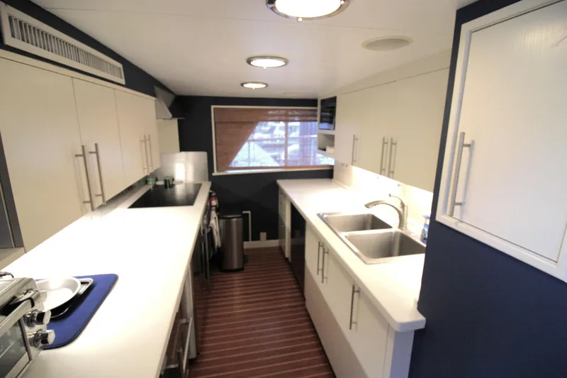 Freedom Yacht Photos Pics Modern kitchen interior on 1979 Burger Raised Pilothouse yacht, featuring sleek countertops and dual sinks.