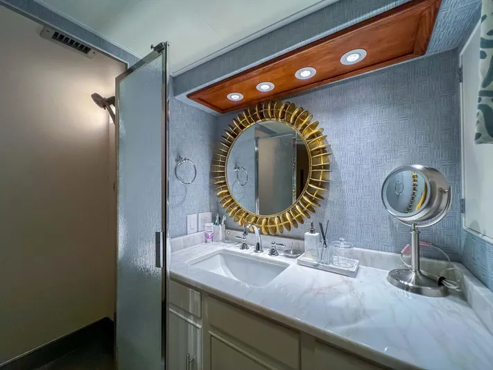 Freedom Yacht Photos Pics Luxurious bathroom on 1979 Burger Raised Pilothouse yacht with elegant gold mirror and modern fixtures.