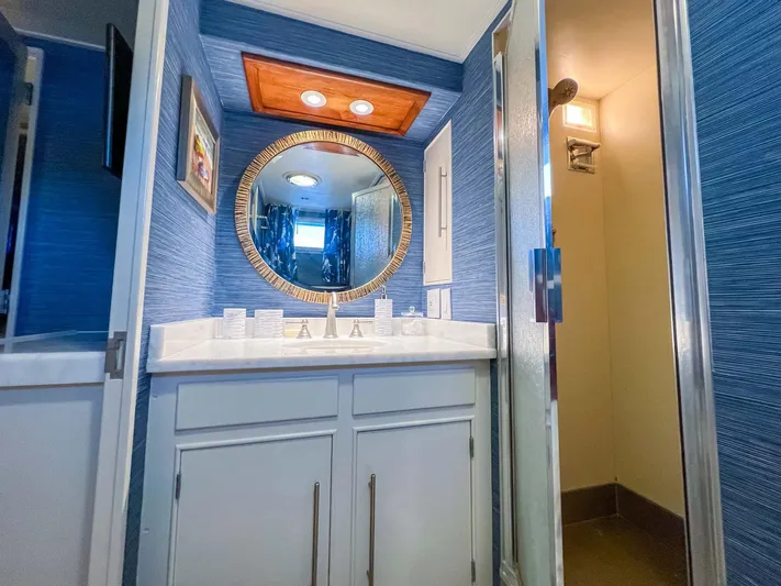 Freedom Yacht Photos Pics Luxurious bathroom on 1979 Burger Raised Pilothouse yacht with blue walls and round mirror.
