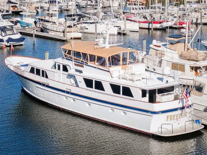 Freedom Yacht Photos Pics 1979 Burger Raised Pilothouse yacht docked in a marina, surrounded by other boats.