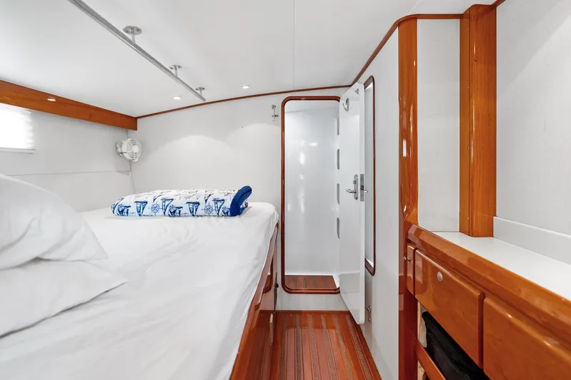 Godspeed Yacht Photos Pics Luxurious yacht cabin with wooden accents, featuring a cozy bed and modern ensuite bathroom.
