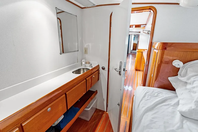 Godspeed Yacht Photos Pics Custom Kelly Archer 1998 yacht interior with wooden cabinetry, sink, and cozy sleeping area.