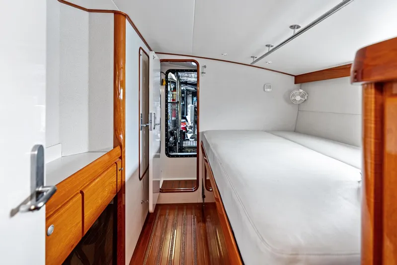 Godspeed Yacht Photos Pics Interior of 1998 Custom Kelly Archer boat cabin with wooden flooring and white bedding.