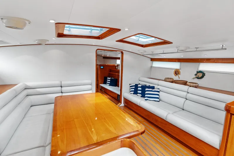 Godspeed Yacht Photos Pics Luxurious yacht interior with white seating, wooden table, and skylights, Custom Kelly Archer 1998 model.