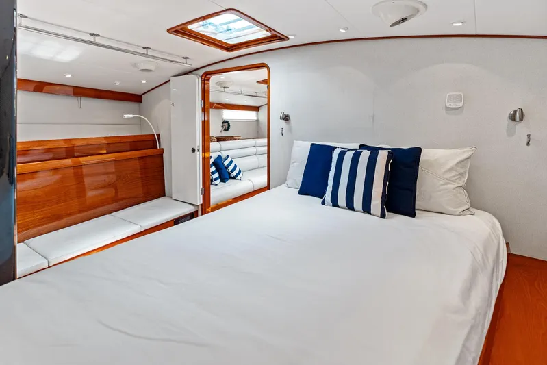 Godspeed Yacht Photos Pics Luxurious yacht bedroom with white bedding, blue pillows, and wooden accents, Custom Kelly Archer 1998.