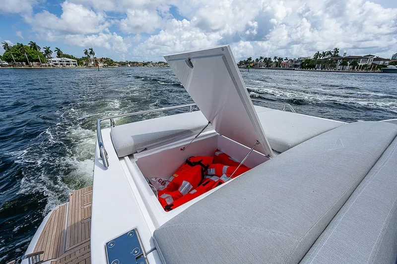  Yacht Photos Pics 2022 Azimut S6 yacht with open storage compartment, life jackets visible, cruising on a sunny day.