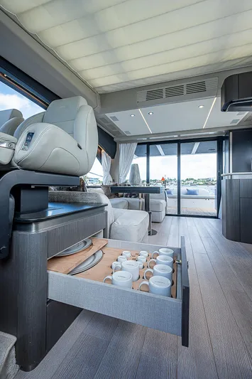  Yacht Photos Pics Luxurious interior of 2022 Azimut S6 yacht with elegant seating and open drawer displaying cups.