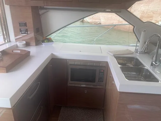  Yacht Photos Pics Modern kitchen interior of 2018 Cruisers Yachts 54 Cantius with sink and microwave.