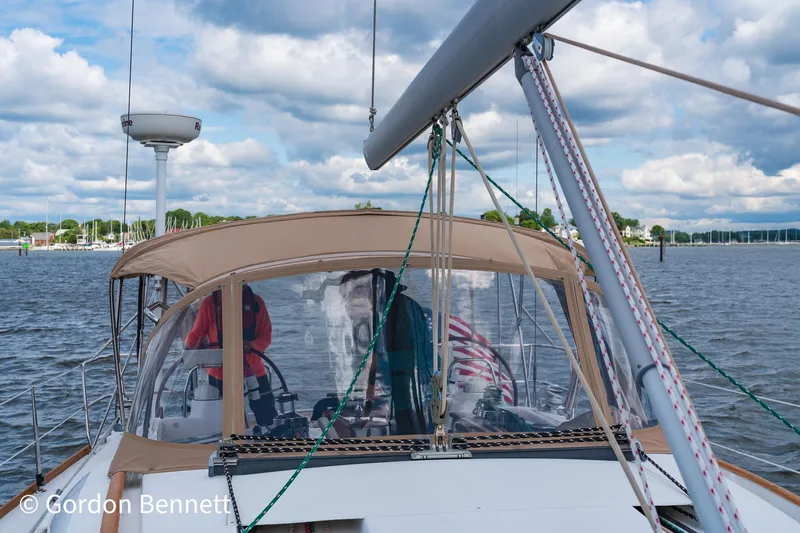 Queens Share Yacht Photos Pics Beneteau Oceanis 43 sailboat, 2008 model, cruising on a calm waterway under a cloudy sky.