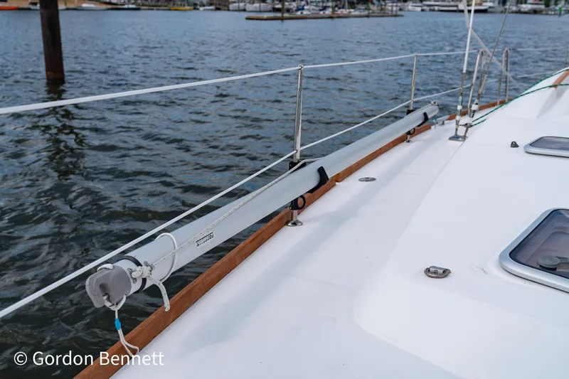 Queens Share Yacht Photos Pics Beneteau Oceanis 43 sailboat deck, 2008 model, with railing and winch, docked by the water.