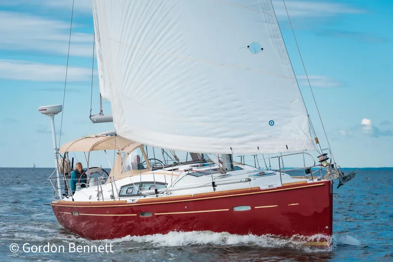 Queens Share Yacht Photos Pics 2008 Beneteau Oceanis 43 sailing on open water with white sails and red hull.