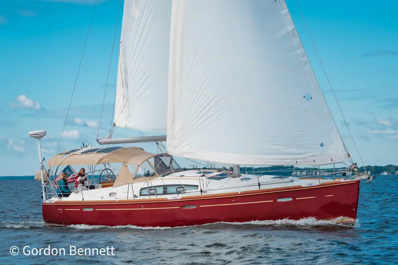 Queens Share Yacht Photos Pics Sailing yacht Beneteau Oceanis 43, 2008 model, with red hull on open water.