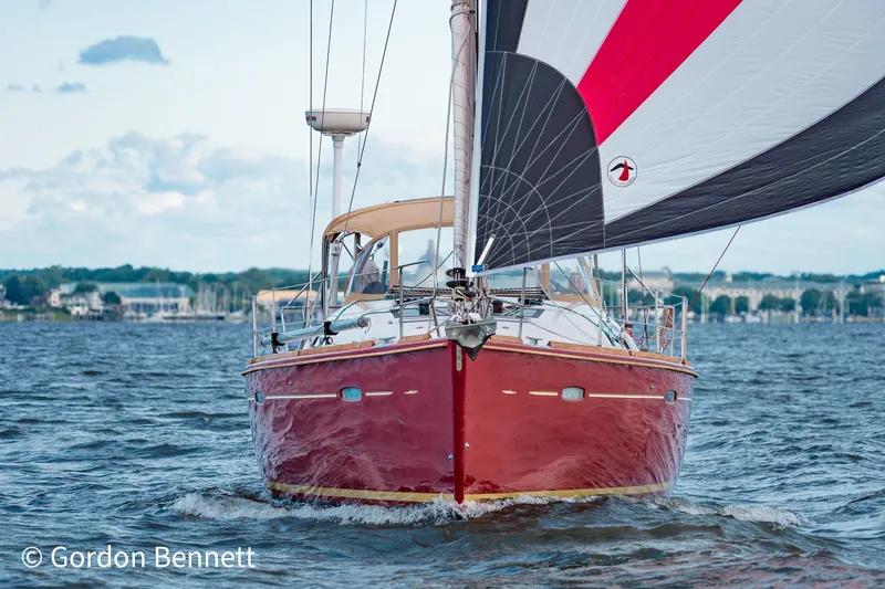 Queens Share Yacht Photos Pics 2008 Beneteau Oceanis 43 sailboat with red hull sailing on open water.