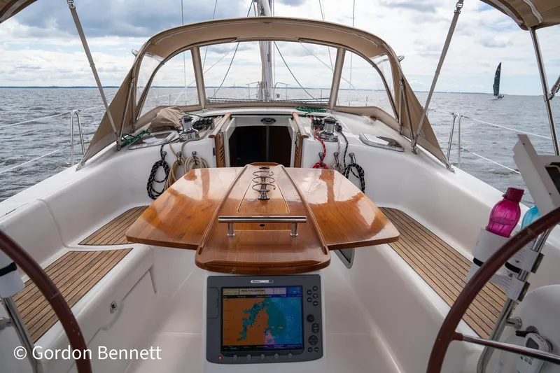 Queens Share Yacht Photos Pics Cockpit of 2008 Beneteau Oceanis 43 sailboat with navigation equipment and wooden table.