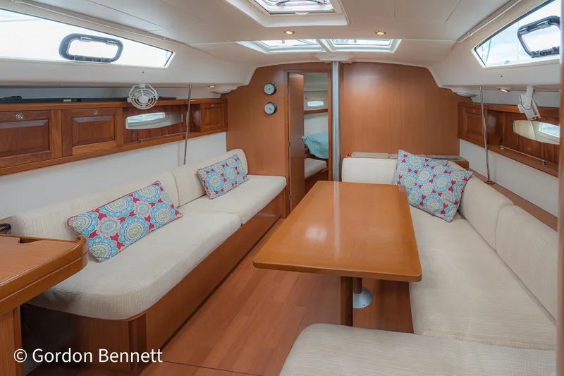 Queens Share Yacht Photos Pics Interior of 2008 Beneteau Oceanis 43 yacht with cozy seating and wooden table.