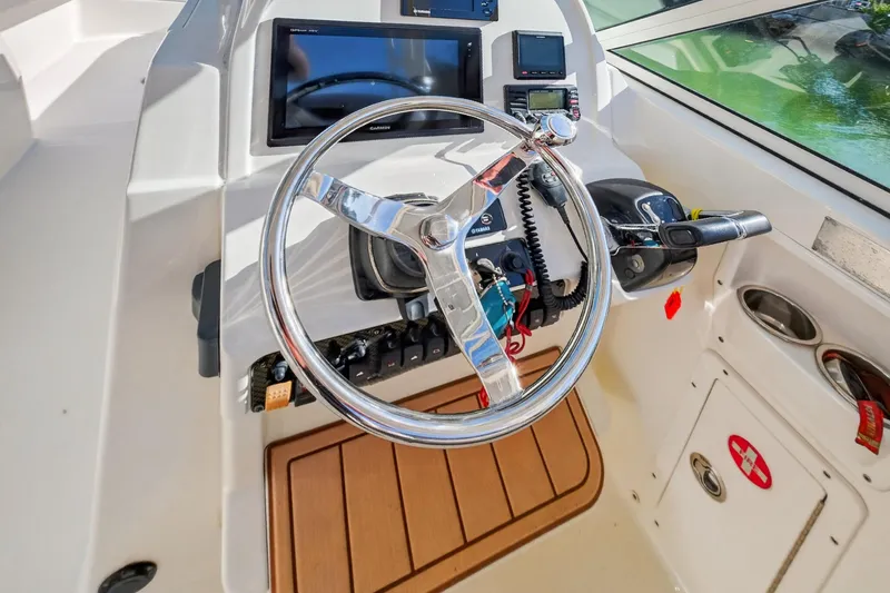  Yacht Photos Pics 2017 World Cat 295 DC boat helm with steering wheel and navigation controls.
