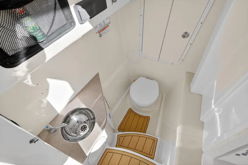  Yacht Photos Pics 2017 World Cat 295 DC boat interior with compact bathroom, sink, and toilet.
