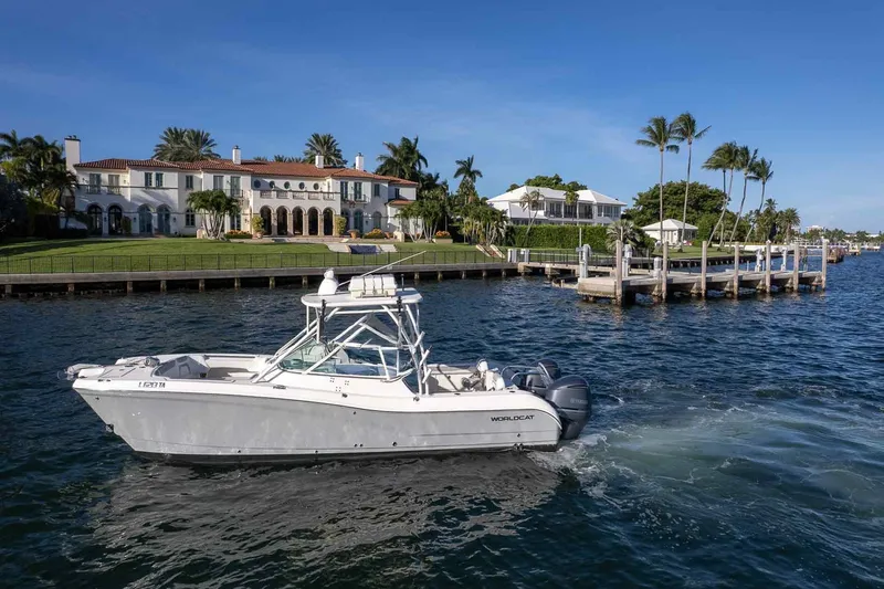  Yacht Photos Pics 2017 World Cat 295 DC boat cruising near luxury waterfront homes and docks.