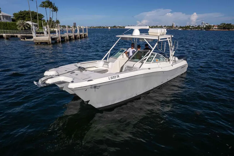  Yacht Photos Pics 2017 World Cat 295 DC boat cruising on a sunny day near a dock.