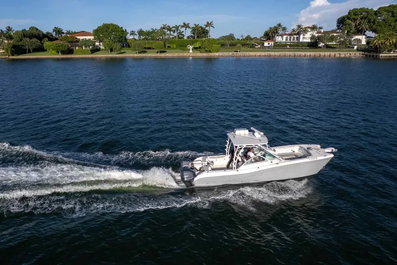  Yacht Photos Pics 2017 World Cat 295 DC cruising on a scenic waterway near luxury homes.