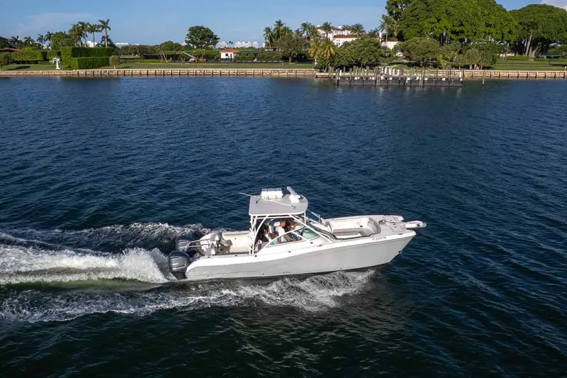  Yacht Photos Pics 2017 World Cat 295 DC cruising on a scenic waterway with lush greenery.