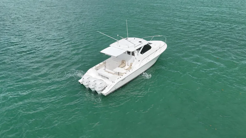  Yacht Photos Pics 2019 Pursuit OS 355 Offshore boat cruising on clear turquoise water.