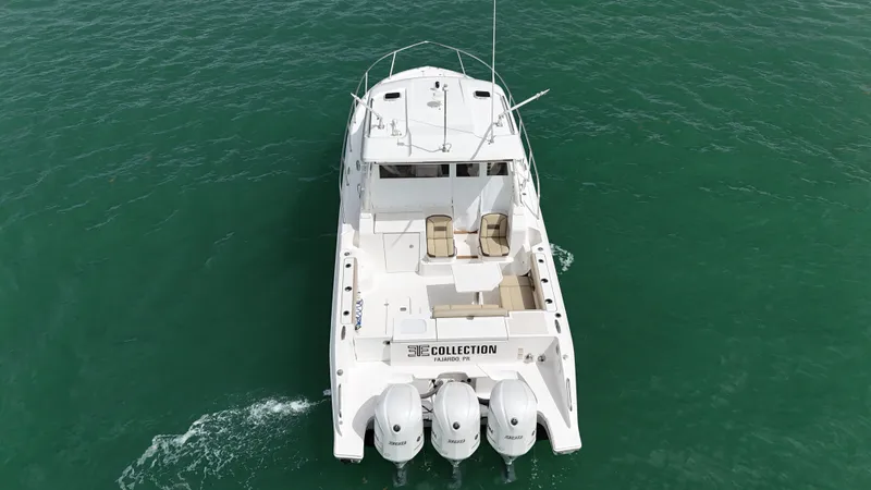  Yacht Photos Pics 2019 Pursuit OS 355 Offshore boat cruising on clear green water.