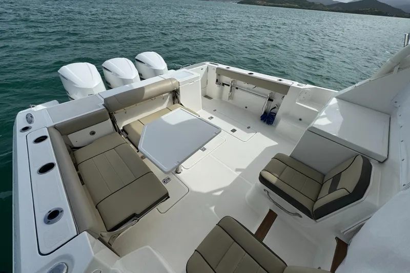  Yacht Photos Pics 2019 Pursuit OS 355 Offshore boat interior with seating and table on calm water.
