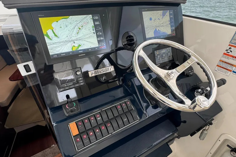  Yacht Photos Pics 2019 Pursuit OS 355 Offshore helm with dual navigation screens and sleek steering wheel.