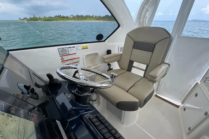  Yacht Photos Pics 2019 Pursuit OS 355 Offshore helm with steering wheel and captain's chair, ocean view.
