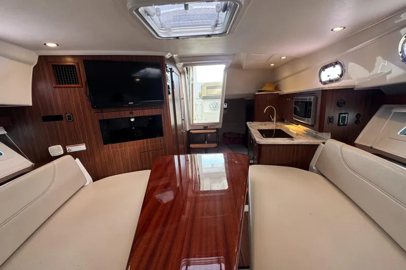  Yacht Photos Pics Luxurious interior of 2019 Pursuit OS 355 Offshore boat with wood finish and modern amenities.
