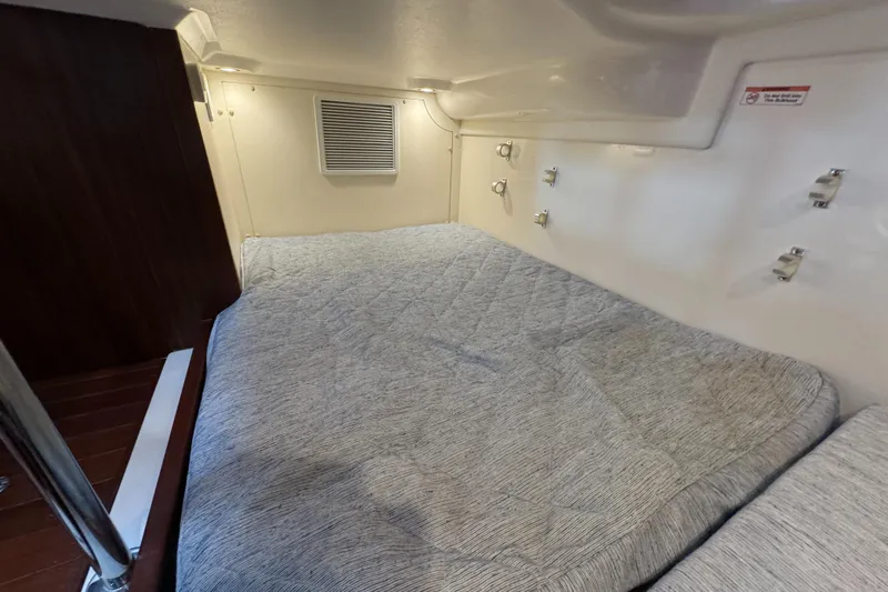  Yacht Photos Pics 2019 Pursuit OS 355 Offshore cabin interior with bed and wooden accents.