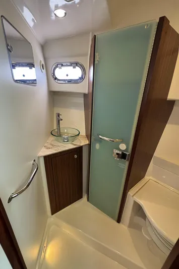  Yacht Photos Pics 2019 Pursuit OS 355 Offshore bathroom with modern fixtures and frosted glass door.