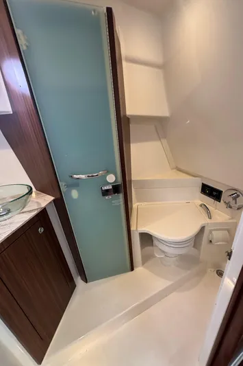  Yacht Photos Pics 2019 Pursuit OS 355 Offshore bathroom with frosted glass door and modern fixtures.