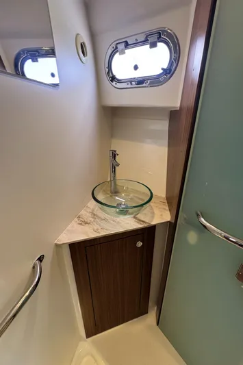  Yacht Photos Pics 2019 Pursuit OS 355 Offshore bathroom with glass sink and porthole window.