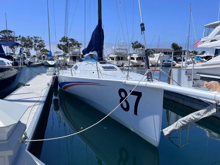 Yippee Kai Yay Yacht Photos Pics Sleek 2009 Class 40 Antrim Design sailboat docked in a marina, numbered 87.