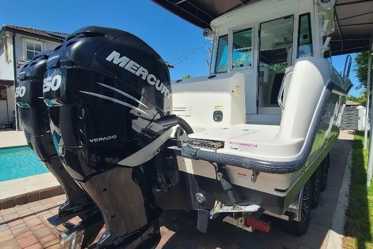 The Snapper Slapper Yacht Photos Pics 2014 Boston Whaler 315 Conquest Pilothouse with twin Mercury Verado engines by a pool.