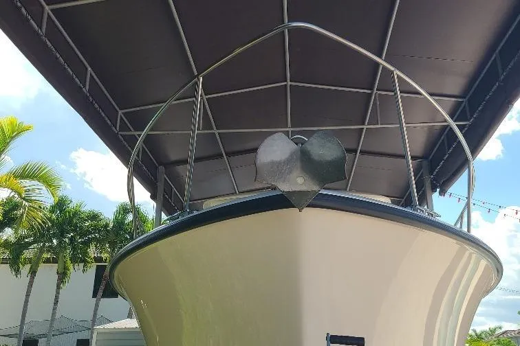 The Snapper Slapper Yacht Photos Pics 2014 Boston Whaler 315 Conquest Pilothouse under canopy with palm trees in background.