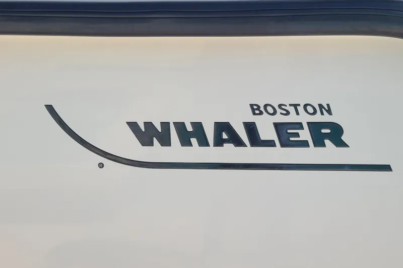 The Snapper Slapper Yacht Photos Pics Boston Whaler logo on 2014 315 Conquest Pilothouse boat, featuring sleek design elements.