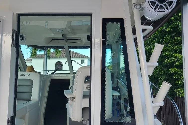The Snapper Slapper Yacht Photos Pics 2014 Boston Whaler 315 Conquest Pilothouse interior view with seating and rod holders.