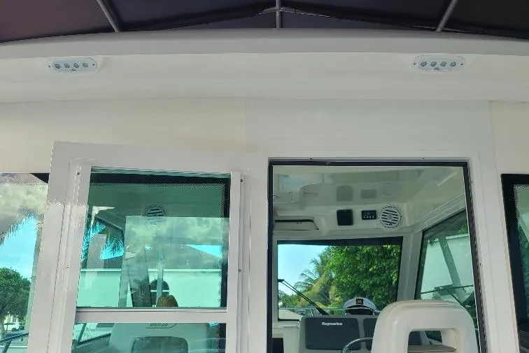 The Snapper Slapper Yacht Photos Pics 2014 Boston Whaler 315 Conquest Pilothouse interior with windows and seating.