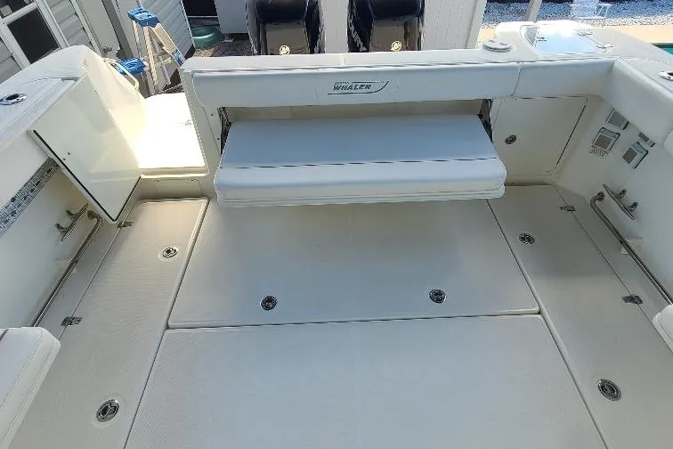 The Snapper Slapper Yacht Photos Pics 2014 Boston Whaler 315 Conquest Pilothouse interior with foldable seating and storage compartments.