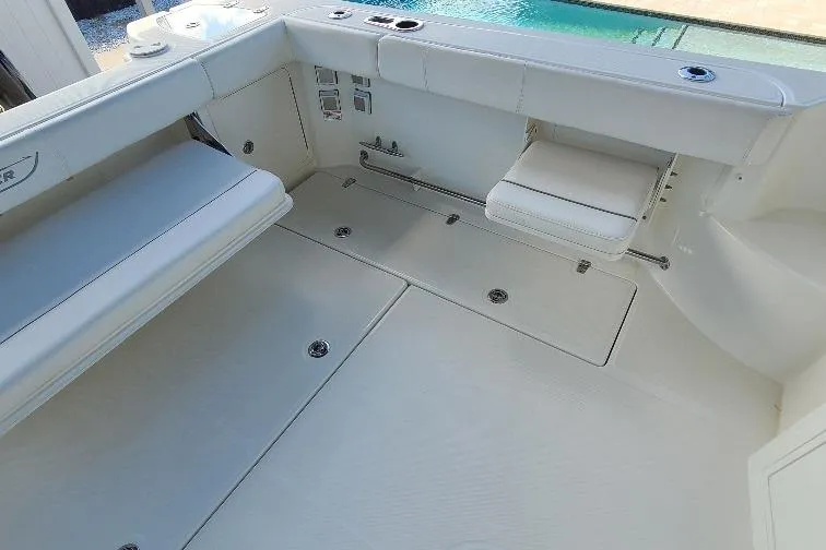 The Snapper Slapper Yacht Photos Pics 2014 Boston Whaler 315 Conquest Pilothouse interior with white seating and storage compartments.