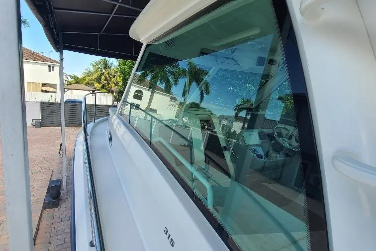 The Snapper Slapper Yacht Photos Pics 2014 Boston Whaler 315 Conquest Pilothouse boat docked under a canopy.