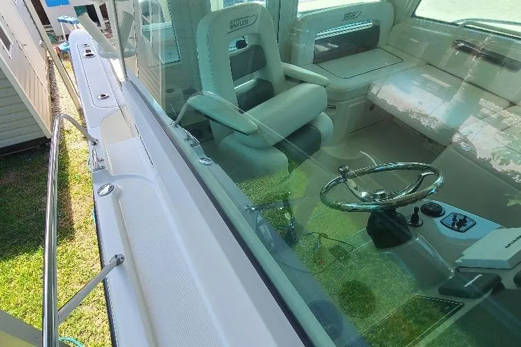The Snapper Slapper Yacht Photos Pics 2014 Boston Whaler 315 Conquest Pilothouse interior with steering wheel and seating.