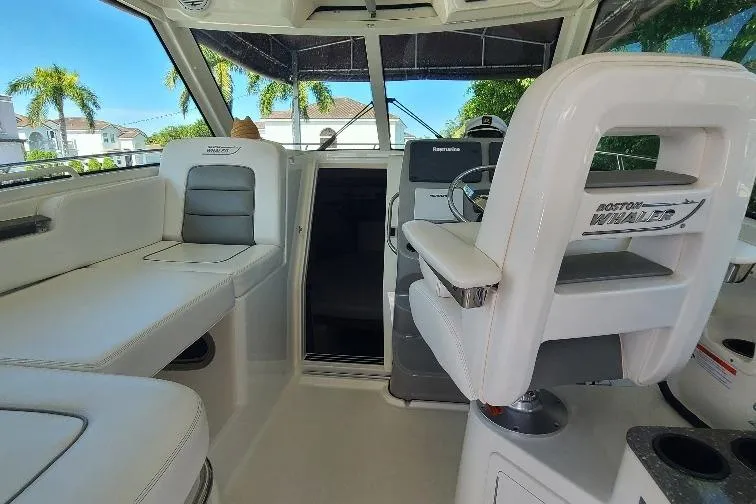The Snapper Slapper Yacht Photos Pics 2014 Boston Whaler 315 Conquest Pilothouse interior with seating and helm, showcasing luxury design.
