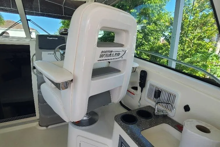 The Snapper Slapper Yacht Photos Pics 2014 Boston Whaler 315 Conquest Pilothouse helm with captain's chair and control panel.