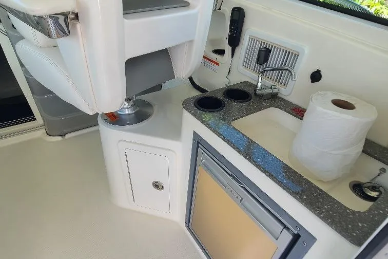 The Snapper Slapper Yacht Photos Pics Interior of 2014 Boston Whaler 315 Conquest Pilothouse with sink, fridge, and seating.