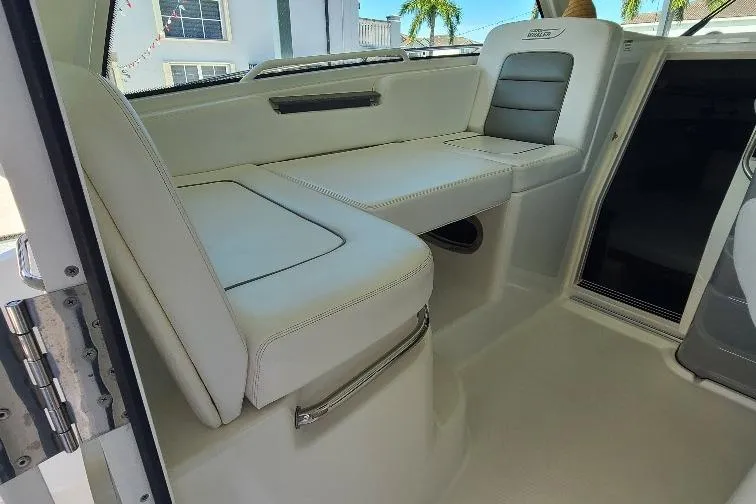 The Snapper Slapper Yacht Photos Pics Interior seating of 2014 Boston Whaler 315 Conquest Pilothouse, featuring white upholstery.